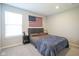 This bedroom features carpet, a bed, window, and an American flag on the wall at 7140 Leatherwood Dr, Indianapolis, IN 46259