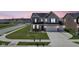 Aerial view of a two-story home boasting a well-maintained lawn and neighborhood street at 7140 Leatherwood Dr, Indianapolis, IN 46259