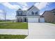 Charming two-story home featuring a well-manicured lawn and a spacious three-car garage at 7140 Leatherwood Dr, Indianapolis, IN 46259