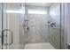 Walk-in shower featuring tile, a window, shelving and glass door at 7140 Leatherwood Dr, Indianapolis, IN 46259