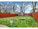 Fenced backyard with a fire pit, shed, mature trees, and ample green space at 725 N Sheffield Ave, Indianapolis, IN 46222