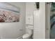 Stylish bathroom with a beach-themed artwork and white storage cabinets above the toilet at 725 N Sheffield Ave, Indianapolis, IN 46222
