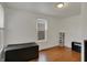 Minimalist bedroom with hardwood floors, a storage trunk, and natural light from the window at 725 N Sheffield Ave, Indianapolis, IN 46222