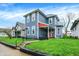 Exterior view of a blue two-story house with a quaint front porch and manicured lawn and neighborhood at 725 N Sheffield Ave, Indianapolis, IN 46222