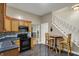 Spacious kitchen with wood cabinets and black appliances, adjacent to a staircase and dining area at 725 N Sheffield Ave, Indianapolis, IN 46222