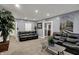 Bright living room features gray walls, plush carpeting, and comfortable black leather sofas and house plants at 725 N Sheffield Ave, Indianapolis, IN 46222