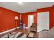 Bright living room featuring hardwood floors, a futon, decorative rug, and a vibrant red accent wall at 725 N Sheffield Ave, Indianapolis, IN 46222