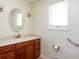Bathroom with wood cabinets, cream walls, and a white framed oval mirror at 7575 Holliday W Dr, Indianapolis, IN 46260