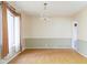 A spacious dining room with hardwood floors, a chandelier, and natural light from the window at 7575 Holliday W Dr, Indianapolis, IN 46260