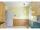 An interior view of the kitchen area featuring light wood cabinets and a light fixture hanging from the ceiling at 7575 Holliday W Dr, Indianapolis, IN 46260