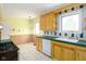 Kitchen with tile floors, yellow walls, wood cabinets, green countertops and white appliances at 7575 Holliday W Dr, Indianapolis, IN 46260