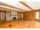 Cozy living room featuring wood paneling, a stone fireplace, and hardwood floors at 7575 Holliday W Dr, Indianapolis, IN 46260