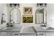 Modern bathroom featuring double vanities, arched mirrors, and stylish lighting fixtures at 7914 Cardinal E Cv, Indianapolis, IN 46256