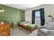 Comfortable bedroom with green accent wall, window, and comfortable chair, great for relaxation at 7914 Cardinal E Cv, Indianapolis, IN 46256