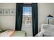 Cozy bedroom with a window overlooking the outdoor scenery, green curtains, and a comfortable chair at 7914 Cardinal E Cv, Indianapolis, IN 46256