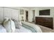 Bright bedroom featuring neutral colors, a dresser with mounted television, and double door closet at 7914 Cardinal E Cv, Indianapolis, IN 46256