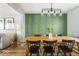 Dining area with light wood table, black chairs, modern light fixture and panelled accent wall at 7914 Cardinal E Cv, Indianapolis, IN 46256