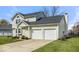 Two-story home with a two-car garage, manicured lawn, and mature landscaping at 7914 Cardinal E Cv, Indianapolis, IN 46256