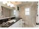 Elegant bathroom featuring sleek granite countertop, white cabinets, toilet and tiled walls at 7915 Allisonville Rd, Indianapolis, IN 46250