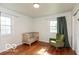 Well-lit bedroom with a crib, comfortable rocking chair, and natural light from two windows at 7915 Allisonville Rd, Indianapolis, IN 46250