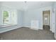 Spacious living room featuring neutral carpet, large windows, fireplace, and fresh paint at 804 N California St, Indianapolis, IN 46202