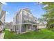 Rear exterior view of a townhouse with a private balcony and a well-maintained lawn at 9769 Marina Village Dr, Indianapolis, IN 46256