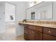 Bathroom features a wood vanity with brass fixtures and granite countertop with a soaking tub in the background at 9769 Marina Village Dr, Indianapolis, IN 46256