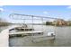 Modern boat dock with lifts on a calm lake, set against a backdrop of waterfront homes and lush landscape at 9769 Marina Village Dr, Indianapolis, IN 46256