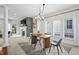 Dining room with modern chandelier, large windows, and an open view to the living space with fireplace at 9769 Marina Village Dr, Indianapolis, IN 46256