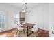 Dining room features white walls, modern chandelier, hardwood flooring, and natural light at 9769 Marina Village Dr, Indianapolis, IN 46256