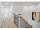 Hallway with carpet, white walls, wooden railing, and doors at 9769 Marina Village Dr, Indianapolis, IN 46256