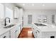 Bright kitchen features stainless steel sink, white cabinets, hardwood floors, and large windows at 9769 Marina Village Dr, Indianapolis, IN 46256