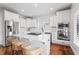 Bright, all-white kitchen featuring an island with a gas cooktop, stainless steel appliances and wood flooring at 9769 Marina Village Dr, Indianapolis, IN 46256