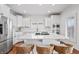 Bright, all-white kitchen featuring an island with a gas cooktop, stainless steel appliances and wood flooring at 9769 Marina Village Dr, Indianapolis, IN 46256