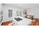 Bright, all-white kitchen featuring an island with a gas cooktop, stainless steel appliances, and a dining area at 9769 Marina Village Dr, Indianapolis, IN 46256