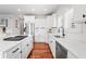 Bright kitchen features stainless steel appliances, white cabinets, hardwood floors, and island gas range at 9769 Marina Village Dr, Indianapolis, IN 46256