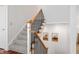 Carpeted staircase with wood and iron railings, complemented by tasteful wall art and bright lighting at 9769 Marina Village Dr, Indianapolis, IN 46256