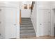 Carpeted staircase with white walls, wooden railings, and landing; hallway doors on either side at 9769 Marina Village Dr, Indianapolis, IN 46256
