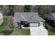 An aerial view showcasing the home's brick facade, well-manicured lawn, and extended driveway leading to a three-car garage at 9831 N Port Dr, McCordsville, IN 46055