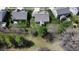 Aerial view of the backyard with mature trees, a fenced yard, and sunroom addition to the home at 9831 N Port Dr, McCordsville, IN 46055