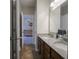 Bathroom featuring a double vanity with granite countertops and dark wood cabinets, adjacent to a Bedroom at 9831 N Port Dr, McCordsville, IN 46055