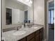 Bathroom featuring a double vanity with granite countertops, a large mirror, and dark wood cabinets at 9831 N Port Dr, McCordsville, IN 46055