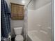 Functional bathroom with a white toilet, shower-tub combination, and cabinet for storage, offering essential amenities at 9831 N Port Dr, McCordsville, IN 46055