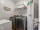 Practical laundry area with modern washer, dryer, and shelving, optimizing space and functionality for household chores at 9831 N Port Dr, McCordsville, IN 46055