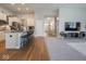 Open-concept living room boasts hardwood floors transitioning into carpet and a kitchen island with bar stool seating at 9831 N Port Dr, McCordsville, IN 46055
