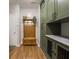 Mudroom features custom olive green cabinets, dog kennel, hall tree, and wood look flooring at 9831 N Port Dr, McCordsville, IN 46055