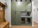This mudroom has custom cabinets, a built-in dog kennel, a hall tree, and hard wood flooring at 9831 N Port Dr, McCordsville, IN 46055
