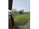 View of spacious backyard with lush green lawn and mature trees from the covered deck at 1010 Pamela Dr, Plainfield, IN 46168