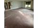 A spacious carpeted living area with staircase access and natural light from large windows at 1010 Pamela Dr, Plainfield, IN 46168
