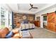 Relaxing main bedroom with a rustic wood accent wall, comfortable seating, and a modern ceiling fan at 10151 E 191St St, Noblesville, IN 46060